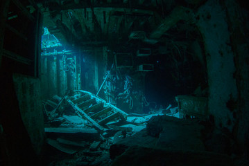 a natural light shot of the inside of the shipwreck of the captain keith tibbetts in little cayman. The inside of this room is a spooky image as the sun lights up a small section - obrazy, fototapety, plakaty