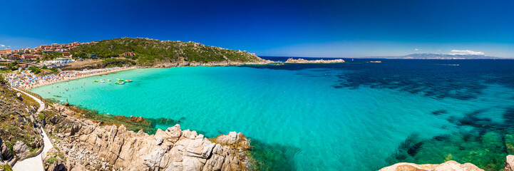 Spiaggia di Rena Bianca beach with red rocks and azure clear water, Smeralda Coast, Sardinia, Italy