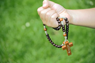 Rosary in child hands close up photo