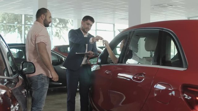 The couple buys a new car in car dealership