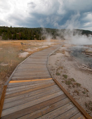 Boardwalk curving around Hot Cascades hot spring in the Lower Geyser Basin in Yellowstone National Park in Wyoming United States