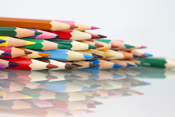 Group of sharp colored pencils with white background and reflexions