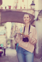 Young woman having pamphlet looking for route