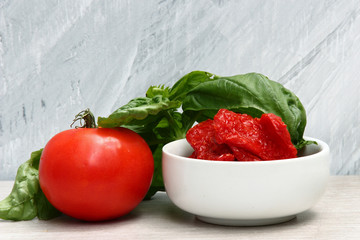 Sun dried Tomatoes with Basil leaves and tomatoes on a stone bac