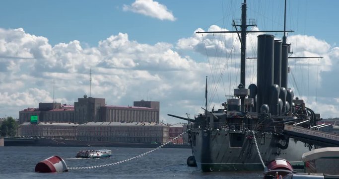 Battle Ship of the Beginning of the Past Century. Cruiser Aurora is moored in the city center. Float past him pleasure boats with tourists