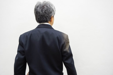Old businessman standing back