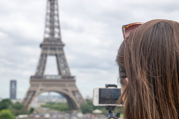 Tourist taking a picture of the Eiffel Tower in Paris