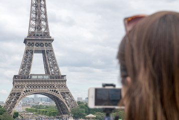 Tourist taking a picture of the Eiffel Tower in Paris