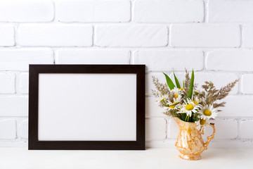 Black brown  landscape frame mockup with chamomile and grass in golden vase