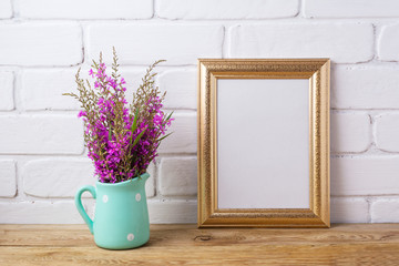 Golden  frame mockup with maroon purple flowers in mint pitcher