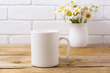 White coffee mug mockup with chamomile bouquet in rustic vase