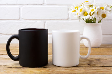 White and black mug mockup with chamomile bouquet in rustic vase