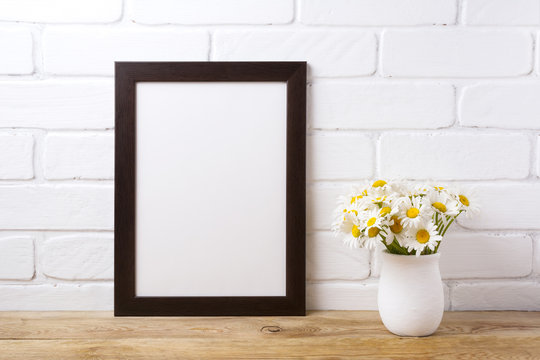 Black brown  frame mockup with chamomile bouquet in rustic vase