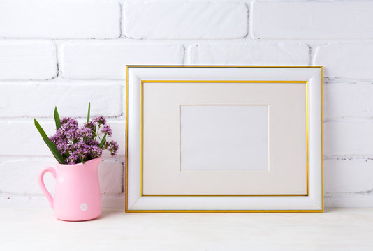 Gold decorated landscape frame mockup with purple flowers in pink rustic pitcher