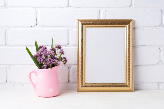 Golden  frame mockup with purple flowers in pink rustic pitcher