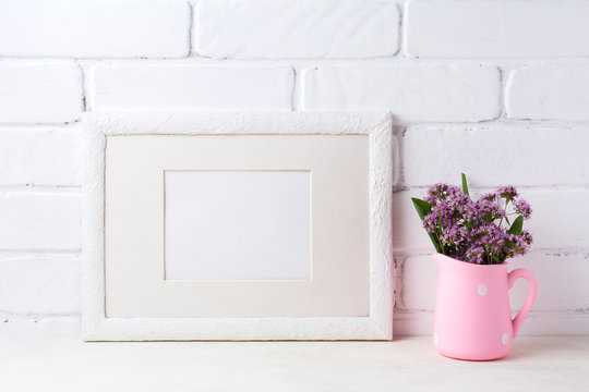 White landscape frame mockup with purple flowers in pink rustic pitcher