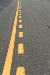 yellow solid and dash line on the asphalt road surface