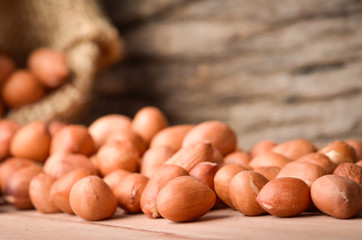 Peanut in burlap bag on old wooden background, close up ,concept of healthy protein power,select focus