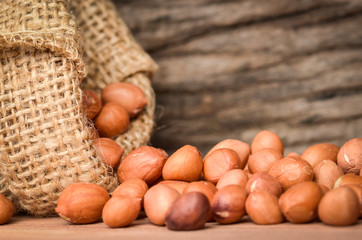 Peanut in burlap bag on old wooden background, close up ,concept of healthy protein power,select focus