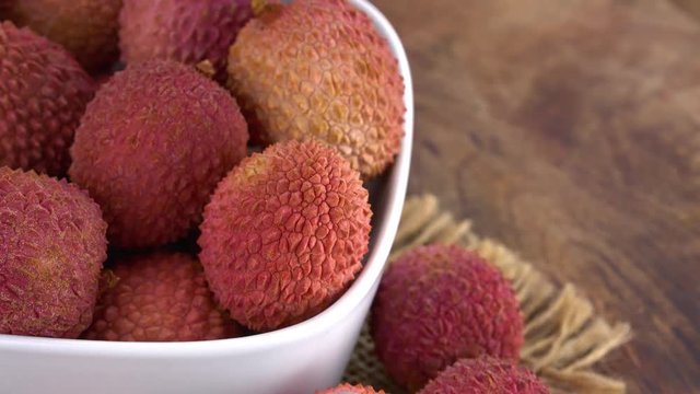 Lychees on a rotating wooden plate (seamless loopable; 4K)