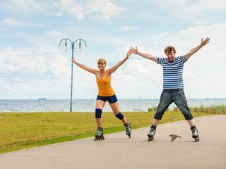 Young couple on roller skates riding outdoors