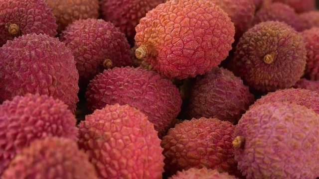 Lychees (rotating on a wooden plate; seamless loopable; 4K)