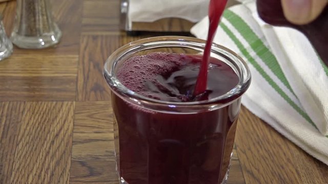 Pouring a glass of concord grape juice