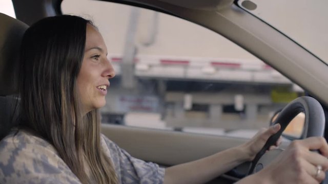 Slow Motion Shot Of Happy Road Tripper Driving On Freeway, Semi Truck Passes Her 