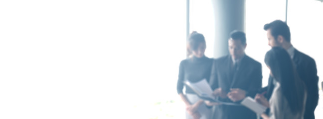 Blurred business people in office interior with space for background or banner design.