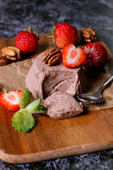Italian dessert. Chocolate panna cotta with mint and strawberry. Dark wood background.