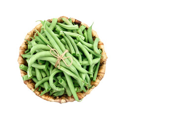 Fresh green beans in a basket on a white background.