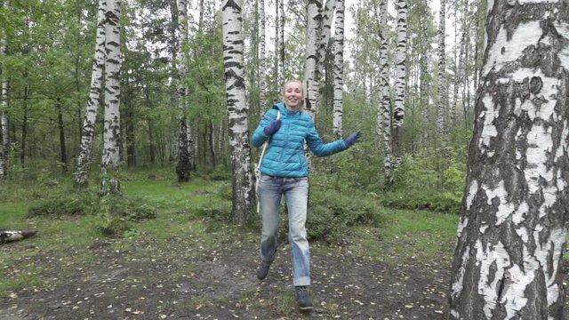 young woman with a long fair hair runs in the birch wood,slow motion
