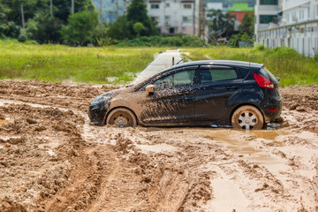 The black car stuck in the mud. Can not fall out of the mud
