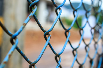 Close up old blue metal chain fence. Selective focus.