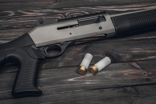 Silver shotgun on a wooden background