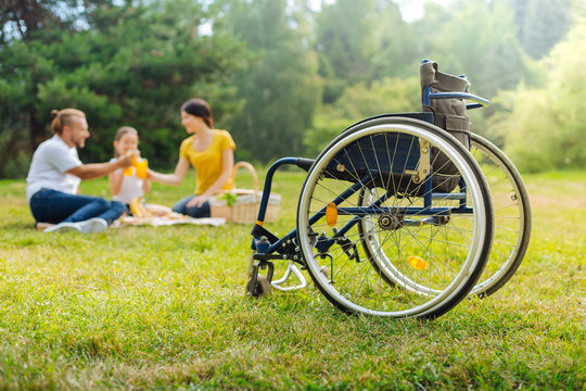 Family of a disabled man drinking juice on picnic