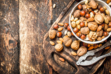 Nuts with Nutcracker in a bowl on the old Board.