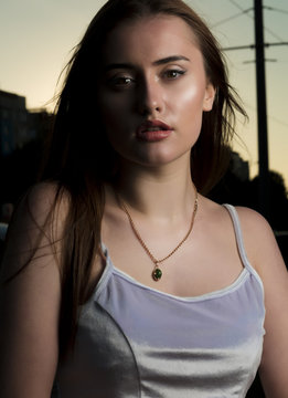 Attractive young woman posing at the street with shadow on her face