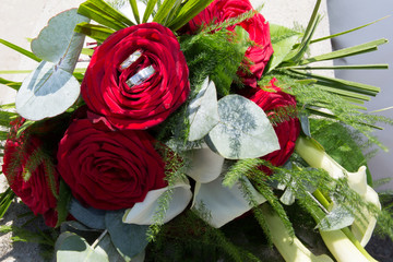 Fototapeta na wymiar rings lie on a beautiful wedding bouquet roses, bridal accessories, European, American