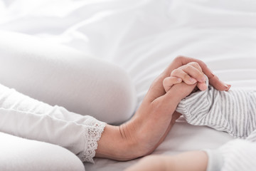 mother holding hand of baby