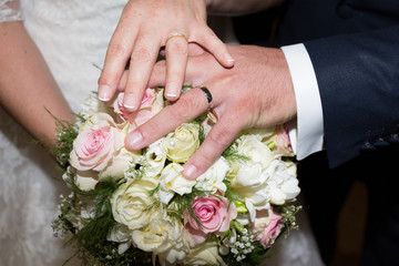 Obraz na płótnie Canvas Newly wed couple's hands with wedding rings