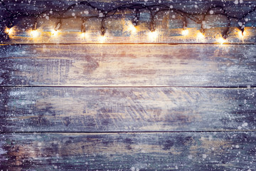 Christmas lights bulb with snow on wood table. Merry christmas (xmas) background. topview, border...