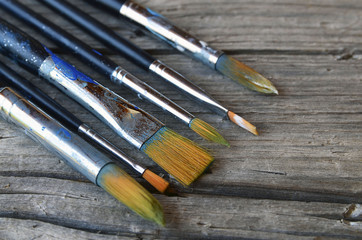 Paint brushes on old wooden background.Set of artistic paintbrushes.Brushes for painting on a rustic table.Selective focus.