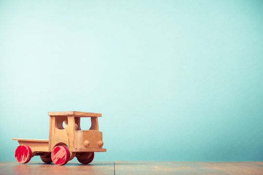 Retro old toy wooden truck front aquamarine background. Vintage instagram style filtered photo