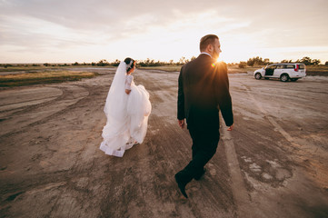 Fototapeta na wymiar Groom and bride on a walk outdoors near the water
