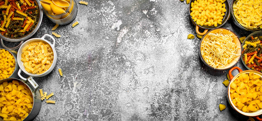 Pasta background. Many different pasta in bowls.