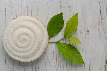 Bowl of white sugar on wood background, top view