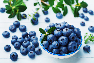 Blueberry or great bilberry in bowl on blue vintage table. Organic superfood and healthy nutrition.