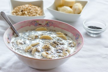 Breakfast dish of oatmeal, banana, milk and poppy seeds