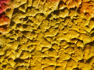 Grungy grainy texture stucco plaster abstract art yellow cement wall, close up